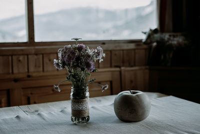 Flower vase on table by window