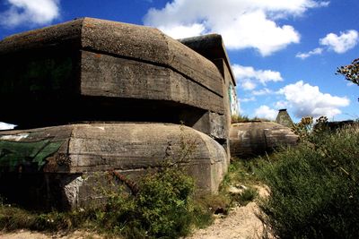 Low angle view of old ruin on field against sky