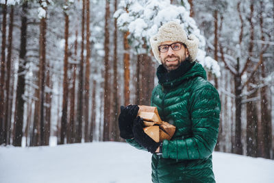 Young woman standing in snow covered forest