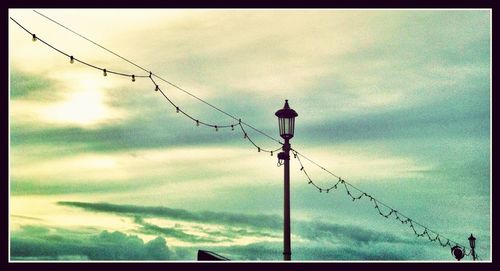 Low angle view of street light against cloudy sky