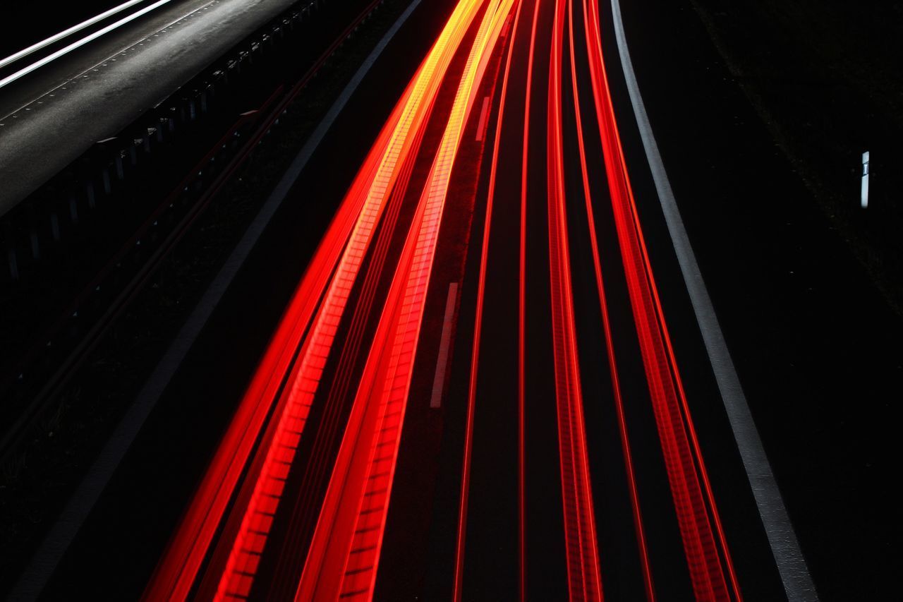 CLOSE-UP OF LIGHT TRAILS ON ROAD AT NIGHT