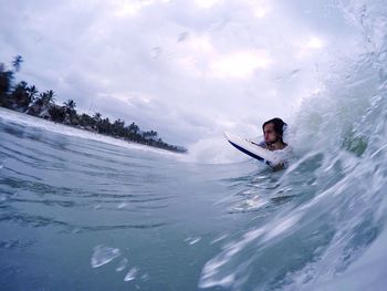 Man surfing on wave in sea