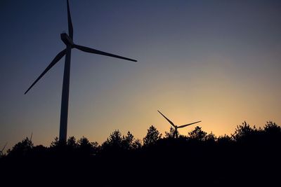 Low angle view of wind turbine against sky at dusk