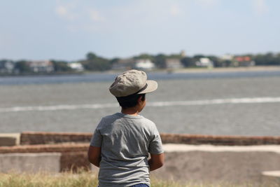 Rear view of man looking at sea against sky