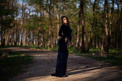 Full length portrait of woman standing in forest