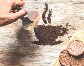 High angle view of hand holding ice cream on table