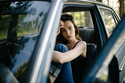 Portrait of young woman sitting in car