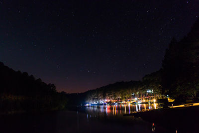 Illuminated lake against sky at night