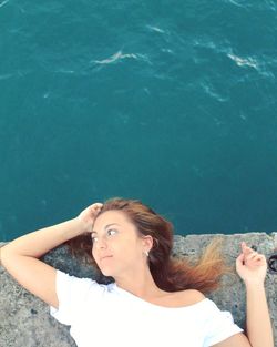 High angle view of young woman relaxing at seaside