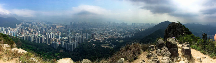 Panoramic view of buildings against cloudy sky