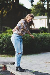 Full length of woman balancing on outdoor play equipment at playground