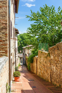 Footpath amidst buildings against sky