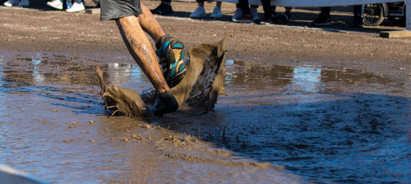 Low section of man running in muddy water