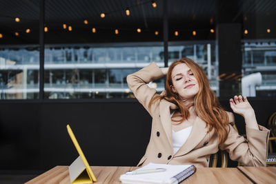 Woman looking down while sitting on table