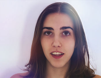 Close-up portrait of young woman against white background