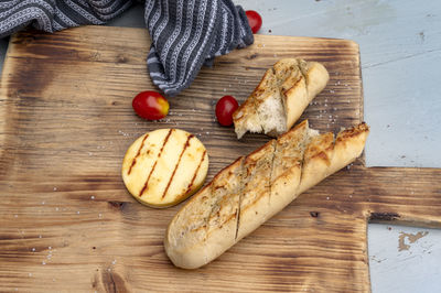 Chopping board with baguette and grilled cheese