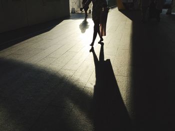 Low section of silhouette person walking on floor