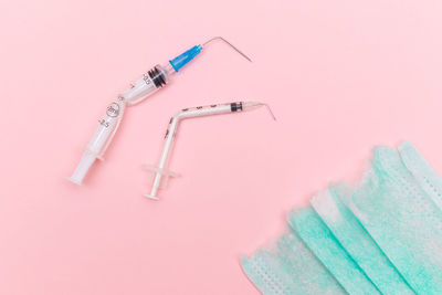 High angle view of doctor with syringe against coral background