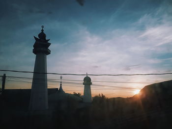 Low angle view of silhouette lighthouse against sky during sunset