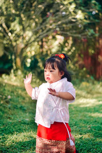 Portrait of young woman standing on field