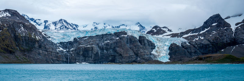Scenic view of sea and mountains against sky