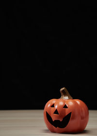 Close-up of pumpkin on table against black background