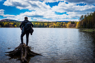 Rear view of man overlooking calm lake