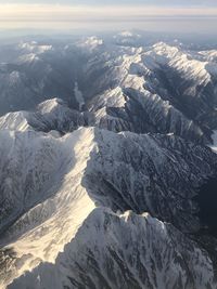 Aerial view of snowcapped mountains against sky