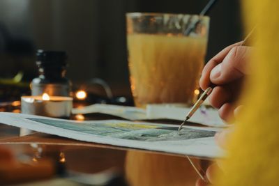 Cropped hand of woman drawing on table