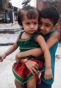 Brother carrying sister wile standing on building terrace during raksha bandhan