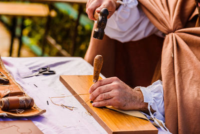 Midsection of craftsmanship working on table