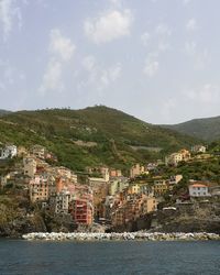 Houses by sea against sky