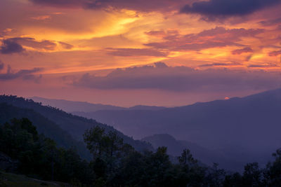 Scenic view of silhouette mountains against sky at sunset