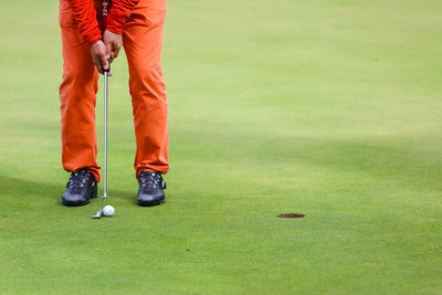 Low section of man standing on golf course