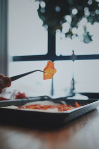 Person hand holding pizza in plate