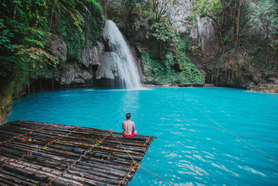 Man looking waterfall in forest