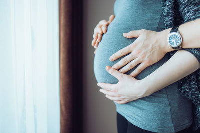 Midsection of woman with hand touching hair