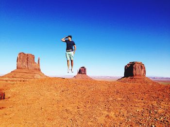 Low angle view of woman standing on cliff