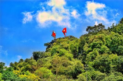 Low angle view of red flag flying against sky