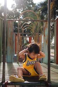 Side view of woman sitting on railing