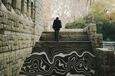 View of people walking on brick wall