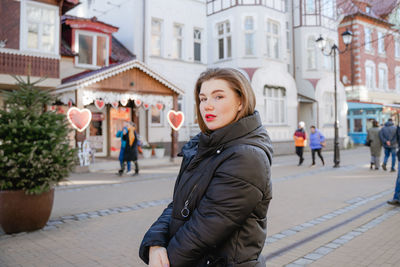 Portrait of woman walking on street in city