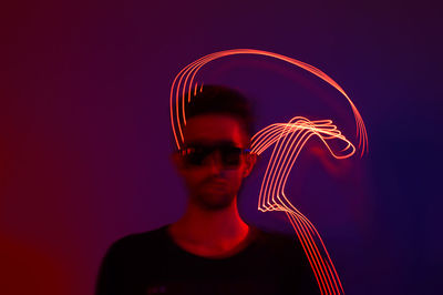 Digital composite image of man against illuminated light