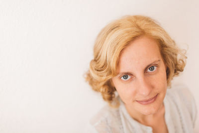 Portrait of woman with blond hair against white background