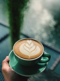 Close-up of hand holding coffee cup