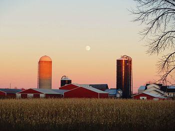 View of farm field against sky during sunset and moon rise