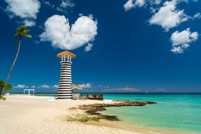 Lifeguard hut on beach against blue sky