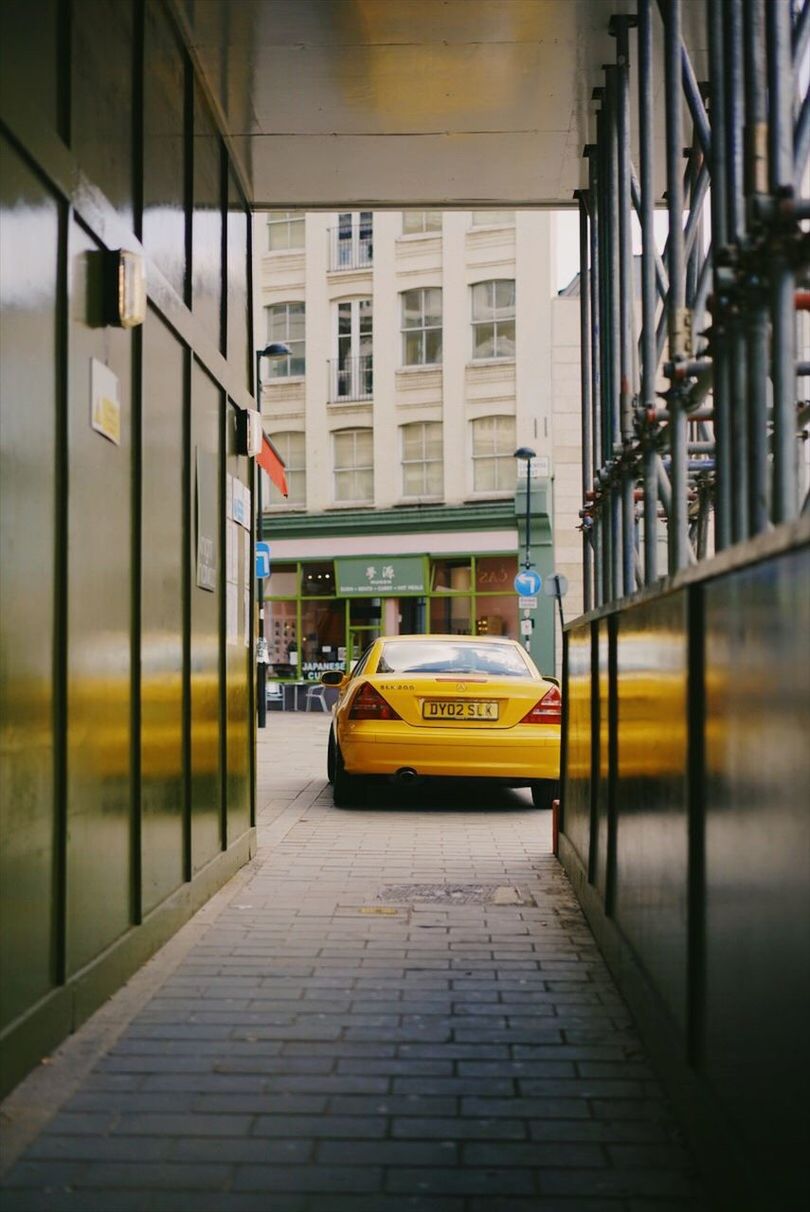 transportation, taxi, yellow taxi, car, built structure, architecture, mode of transport, building exterior, yellow, street, land vehicle, city, public transportation, day, outdoors, no people