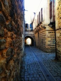 Walkway amidst buildings in city