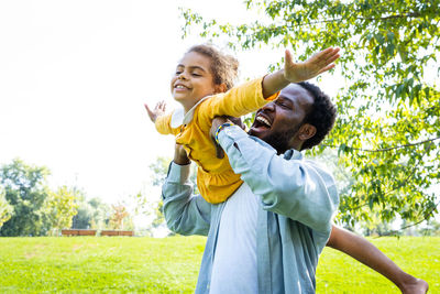 Portrait of smiling young woman exercising on field